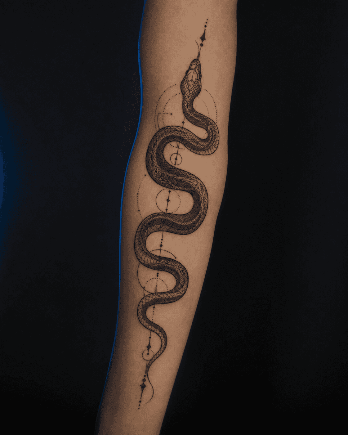 Ornamental snake tattoo on forearm